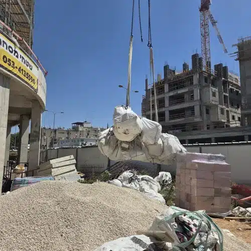 צוות אגם מעמיס באלות פסולת בניין באתר עבודה